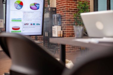 Dijital monitör ve içecek olarak su dağıtıcısının yer aldığı boş ofis, profesyonel araştırma için hazırlandı. Girişimdeki hiç kimse beyin fırtınası için toplantı alanı oluşturmuyor..