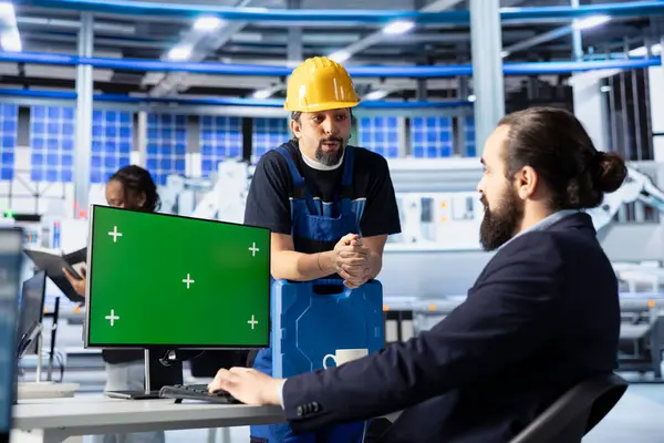 Photovoltaics fabrika müdürü işçilere üretim akışını nasıl optimize edeceğini göstermek için yeşil ekran PC kullanıyor. Sürdürülebilir enerji güneş panelleri bitki denetleyicileri model bilgisayarda üretim süreci