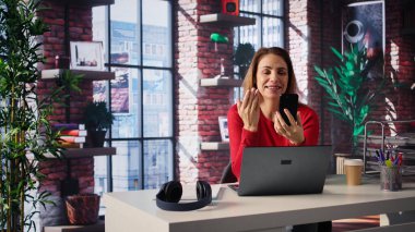 Kadın serbest çalışan ev ofisinden yeni beceriler edinmek için online kurs alıyor, online video görüşmelerine katılıyor ve akıllı telefondan ders izliyor. Bayan sanal eğitim sınıfına katılıyor. Kamera B.