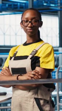 Verimliliği arttırmak için öngörü algoritmaları üzerinde çalışan mutlu akıllı fabrika mühendisinin dikey video portresi. Neşeli endüstri 4.0 fabrika teknisyeni, tesisin zeminini denetliyor.