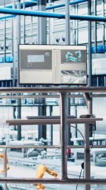 Endüstriyel otomasyon yazılımını gösteren dikey video monitörü. Robotik kolları, modüler üretim birimleri, bağlı makineleri ve kontrol sistemleri olan 4.0 akıllı fabrika.
