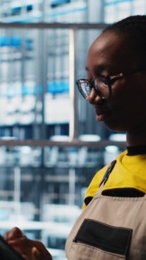 Akıllı fabrikada tablet kullanan dikey video işçisi veri toplayıp analiz ediyor. Gelişmiş sensörlerle donatılmış 4.0 endüstriyel santralde izleme yazılımı kullanan uzman, kamera A