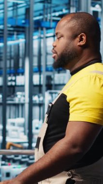 Dikey video akıllı fotovoltaik fabrika uzmanı dizüstü bilgisayardaki sistem performans ölçümlerine bakıyor. Afrika Amerika güneş panelleri fabrika işçisi IoT sensörleri aracılığıyla enerji üretimini izliyor