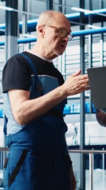 Dikey video akıllı fabrika kıdemli mühendisi stajyere otomatik iş akışlarını uygulamayı ve elle işlemleri bilgisayara geçirmeyi öğretiyor. Tecrübeli bir adam stajyerin sensörleri üretime ve kameraya entegre etmesine yardım ediyor.