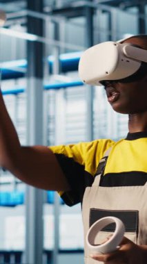 Akıllı fabrikada VR kulaklık takan dikey video mühendisi optimizasyon yapmak için toplanan verilere bakıyor. Sanayide sanal gerçeklik kullanan teknisyenler sensörlerle donatılmış 4.0 endüstriyel fabrika