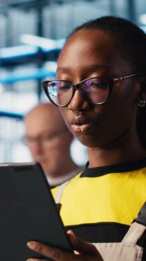 Dikey video akıllı fabrika mühendisi tablet kullanarak otomatik iş akışı ve kontrol sistemleri uygular, elle işlemleri bilgisayara geçirir. Sektör 4.0 çalışanı sensörleri üretime entegre ediyor