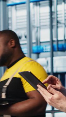 Tabletteki sistem performans ölçümlerine bakan akıllı fotovoltaik fabrikasında kıdemli mühendis. Deneyimli güneş panelleri fabrika işçisi IoT sensörleri aracılığıyla enerji üretimini izliyor