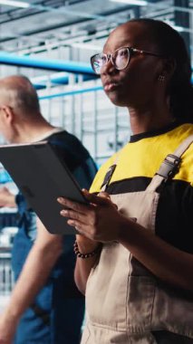 Dikey video akıllı fabrika mühendisi tablet kullanarak otomatik iş akışı ve kontrol sistemleri uygular, elle işlemleri bilgisayara geçirir. Sektör 4.0 çalışanı sensörleri üretime entegre ediyor