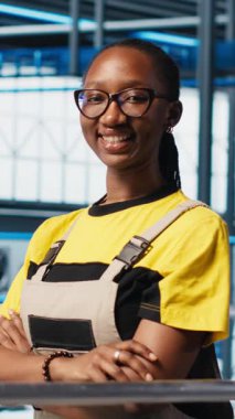 Neşeli akıllı güneş panellerinin dikey video portresi öngörücü bakım algoritmaları üzerinde çalışan fabrika uzmanı imalatı. Gülümseyen Afro-Amerikan kadın Endüstri 4.0 fabrika denetleme tesisi