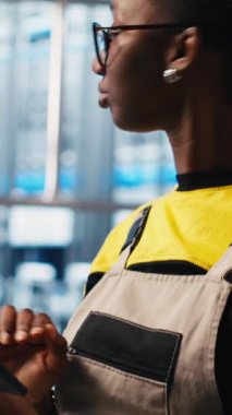 Dikey video endüstrisi 4.0 endüstriyel fabrika uzmanı tablet kullanarak otomatikleştirilmiş makineleri kontrol ediyor ve iş akışının devamlılığını sağlıyor. Akıllı fabrika çalışanı robotik silah ve taşıma bantları ile yönetiyor