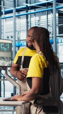 Akıllı fabrikadaki dikey video sistemi yöneticileri veri toplayıp analiz ediyorlar. İş arkadaşları beyin fırtınası yapıyor, gelişmiş sensörlerle donatılmış endüstriyel fabrikada izleme yazılımı kullanıyorlar, kamera A