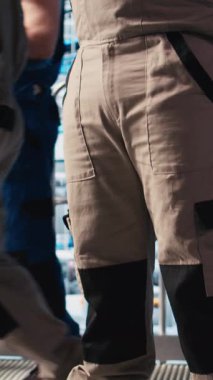 Dikey video endüstrisi 4.0 fotovoltaik fabrika mühendisi güneş pillerinin enerji üretimini maksimuma çıkarmak için tablet üzerinde yazılım kullanıyor. Güneş panellerini denetleyen Afrikalı Amerikalı adam akıllı fabrika.