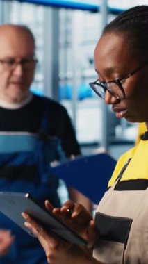 Akıllı fabrikadaki dikey video mühendisi otomatik iş akışlarını ve kontrol sistemlerini uyguluyor manüel işlemleri bilgisayarlı süreçlerle değiştiriyor. Teknisyen sensörleri üretime entegre ediyor