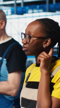 Fotovoltaik 'teki dikey video mühendisi. Akıllı fabrika çalışanı ile konuşuyor. Arızalı IoT sensörlerini tespit ediyor. Endüstri 4.0 güneş panelleri, çalışma saatlerini azaltmak için beyin fırtınası yapan meslektaşları yerleştirdi