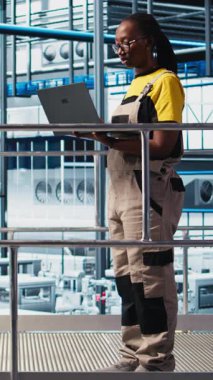 Dikey video akıllı fotovoltaik fabrika mühendisliği ekibi sistem performans ölçümlerine bakıyor. Takım çalışması güneş panelleri enerji üretimini IoT sensörleri ve kamera A üzerinden takip eden iş arkadaşları.