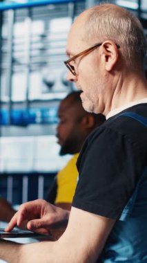 Dikey video akıllı fabrika uzmanı otomatik sistemleri test etmek ve güvenilirliği sağlamak için dizüstü bilgisayar yazılımı kullanıyor. İşçi, dizüstü bilgisayarda dar geçitleri tanımlamak ve sensörlere dayalı donanımı optimize etmek için program kullanır