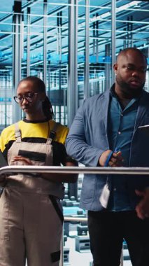 Dikey video Photovoltaics akıllı fabrika kalite kontrol subayı sistem tasarımı ve güvenilirliğini denetliyor. Sanayi 4.0 güneş paneli üretim tesisi müfettişi çalışanlara geri bildirim sağlıyor