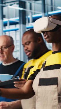 VR kulaklık takan dikey video Smart fotovoltaics fabrika uzmanı sistem performans ölçümlerine bakıyor. Güneş panelleri fabrika işçisi IOT aracılığıyla enerji üretimini izlemek için sanal gerçeklik teknolojisi kullanıyor