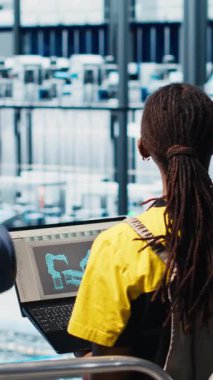 Dikey video yöneticisi sektör 4.0 endüstriyel fabrikayı denetliyor CAD yazılımı kullanarak makine dizayn eden işçilere talimatlar veriyor. Akıllı fabrika yöneticisi mühendislere otomasyon geliştirme görevi verdi