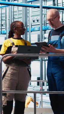 Sektör 4.0 güneş panelleri fabrikası mühendisleri tarafından yapılan kesintileri azaltmak için yapılan dikey video denetleyicisi denetimi. Photovoltaics akıllı fabrika yöneticisi işçilere hasarlı IoT sensörlerini tamir etme görevi veriyor