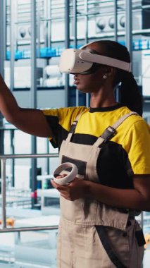 Dikey video akıllı fabrika mühendisi sanal gerçeklik kullanarak otomatik iş akışı ve kontrol sistemleri uygular, işlemleri bilgisayara geçirir. Teknisyen sensörleri VR kulaklık kullanarak üretime entegre ediyor.