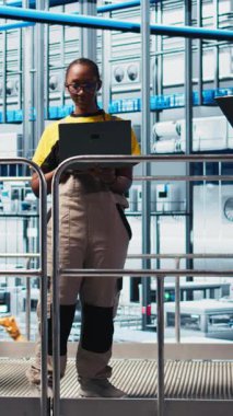 Dikey video endüstrisi 4.0 fotovoltaik fabrika yöneticisi çalışanlar tarafından güneş enerjisi üretimini maksimuma çıkarmak için yapılan çalışmaları denetliyor. Güneş panelleri akıllı fabrika yöneticisi koordinasyon teknisyenleri