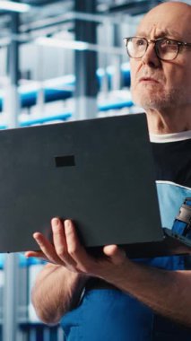 Dikey video mühendisi, otomatik sistemleri test etmek ve güvenilirliği sağlamak için akıllı fabrikada dizüstü bilgisayar kullanır. Deneyimli teknisyen, darboğazları tanımlamak ve ekipmanları optimize etmek için dizüstü bilgisayar kullanır