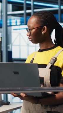 Sistem performans ölçümlerine bakan akıllı fotovoltaik fabrikasındaki mutlu mühendisin dikey video portresi. Güneş panellerindeki neşeli işçi IoT sensörleri aracılığıyla enerji üretimini takip ediyor.