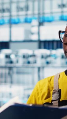 Dikey video akıllı fabrika lideri otomatik sistemleri test etmek ve güvenilirliği sağlamak için yeni stajyerler öğretiyor. Kıdemli mühendis staj yapıyor, onları darboğazları tespit etmek için eğitiyor.