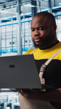 Dikey video akıllı fabrika profesyonel uygulamaları otomatik iş akışları ve kontrol sistemleri dizüstü bilgisayar ve manüel işlemler kullanır. Adam sensörleri dizüstü bilgisayarla üretime entegre ediyor.