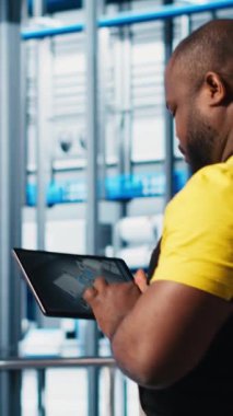 Dikey video Photovoltaic akıllı fabrika mühendisi CAD programı için üretim hatları tasarlamak için tablet kullanır. Sanayi 4.0 güneş panelleri fabrika işçisi zemini optimize etmek için aygıt kullanıyor