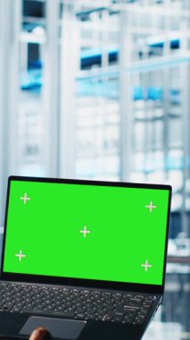 Akıllı fabrikada yeşil ekran dizüstü bilgisayar kullanan dikey video işçisi veri toplayıp analiz ediyor. Gelişmiş teknolojiyle donatılmış endüstriyel santralde krom anahtar defteri üzerinde izleme yazılımı kullanan uzman