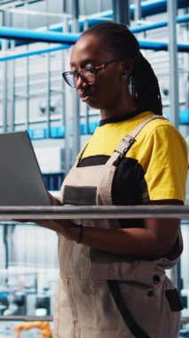 Dikey video akıllı fabrika mühendisi tesis katındaki robotik silah ve taşıma sistemlerini denetliyor. Sanayi 4.0 fabrika teknisyeni sistem performansını izliyor ve sorun yaratıyor