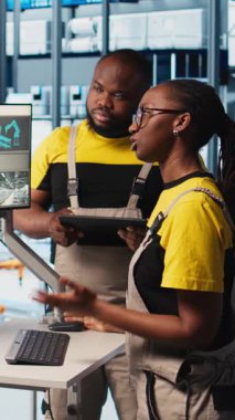 Dikey video deneyimli takım lideri 4.0 fotovoltaik fabrikasında yeni öğrencilere indüksiyon yapıyor. Akıllı güneş panelleri fabrikasında kıdemli mühendis stajyerlere enerji üretimini maksimuma çıkarmayı öğretiyor.