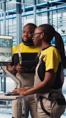 Dikey video Photovoltaics akıllı fabrika ekip lideri ve işçiler yeni PV materyalleri hakkında konuşuyor. Sanayi 4.0 güneş panelleri kıdemli mühendis ve meslektaşları yeşil enerji sistemleri prototipleri geliştiriyor