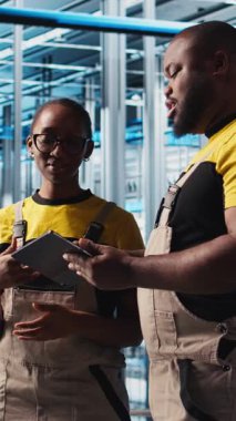 Dikey video akıllı fabrika mühendisliği ekibi güvenilirliğini sağlamak için otomatik sistemleri test ediyor. Sanayi 4.0 sanayi işçileri darboğazları tespit etti ve verilere dayanarak teçhizatı optimize etti