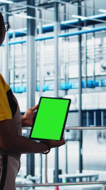 Dikey video akıllı fabrika mühendisi yeşil ekran tableti kullanarak otomatik iş akışları uygular, elle işlemleri bilgisayara geçirir. Teknisyen sensörleri kroma anahtarı kullanarak üretim hatlarına entegre ediyor.