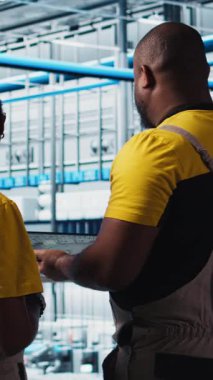 Dikey video ekibi zeki fabrika meslektaşları beyin fırtınası yapıyor, otomasyon ekipmanları programlıyor. Sanayi 4.0 fabrika çalışanları CAD yazılımı kullanarak robotik makineler tasarlamak için birlikte çalışıyorlar