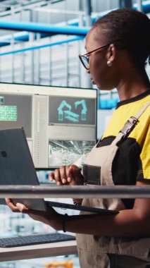 Akıllı fabrikayı denetleyen gülen bir mühendis dizüstü bilgisayar ekranında toplanan ölçülere bakıyor. Endüstri 4.0 endüstriyel fabrikasında sensörlerle donatılmış mutlu teknisyen.