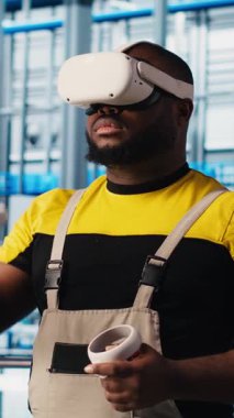 Sanayi 4.0 güneş paneli fabrikasında sanal gerçeklik teknolojisi kullanan dikey video mühendisi yenilenebilir enerji üretiyor. Fotovoltaik teknisyeni. Akıllı fabrika. VR kulaklık ve kamera A kullanarak veri analiz ediyor.