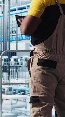 Dikey video Photovoltaic akıllı fabrika mühendisi CAD programı için üretim hatları tasarlamak için tablet kullanır. Sanayi 4.0 güneş panelleri fabrika işçisi zemini optimize etmek için aygıt kullanıyor