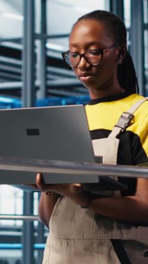 Dikey video akıllı fotovoltaik fabrika mühendisliği ekibi sistem performans ölçümlerine bakıyor. Takım çalışması güneş panelleri enerji üretimini IoT sensörleri ve kamera A üzerinden takip eden iş arkadaşları.