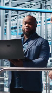 Dikey video akıllı fabrika müdürü personele robotik kolları dizüstü bilgisayarla kullanmayı öğretiyor. Denetleyici endüstri 4.0 Endüstriyel Sanayi Fabrikası, otomatik makine dizüstü bilgisayarı, kamera A