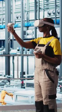 Dikey video endüstrisi 4.0 endüstriyel sanayi mühendisi otomatikleştirilmiş makineleri kontrol etmek için sanal gerçekliği kullanarak iş akışının devamlılığını sağlıyor. Akıllı fabrika teknisyeni VR kullanarak robotik kolları yönetiyor.