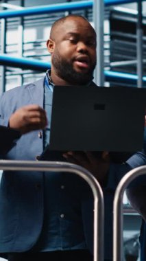 Dikey video akıllı fabrika müdürü çalışanlarla otomatik iş akışı uygulamasını tartışıyor. İşçilerle yapılan sanayi fabrikası görüşmelerini denetleyen, sensörleri üretime entegre eden, kamera