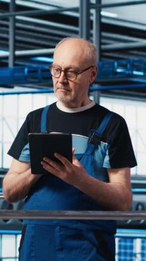 Dikey video endüstrisi 4.0 fotovoltaik fabrika yöneticisi çalışanlar tarafından güneş enerjisi üretimini maksimuma çıkarmak için yapılan çalışmaları denetliyor. Güneş panelleri akıllı fabrika yöneticisi koordinasyon teknisyenleri