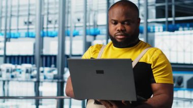 Mutluluk mühendisi, 4.0 endüstriyel sanayi santralindeki dizüstü bilgisayarını kullanarak makineler kuruyor ve eksiksiz testler yapıyor. Neşeli robot teknisyeni akıllı fabrikada IoT sensörlerini ayarlayan bir defter kullanıyor.