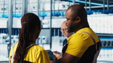 Endüstri 4.0 endüstriyel fabrika mühendisliği ekibi tablet üzerinde CAD uygulaması kullanarak yeni robotik makineler tasarlıyor. Takım çalışması akıllı fabrika çalışanları otomasyon ekipmanları programlıyorlar, kamera A