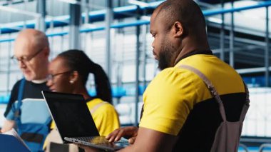 Fotovoltaik akıllı fabrika teknisyeni bilgisayar yazılımı kullanarak hasarlı IoT sensörlerini tamir ediyor. Endüstri 4.0 güneş panelleri, dizüstü bilgisayarı kullanarak bitki uzmanı hata bulun ve çalışma süresini azaltın, kamera A