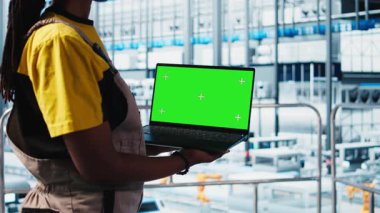 Akıllı fabrikada yeşil ekran dizüstü bilgisayar kullanan işçiler veri toplayıp analiz ediyorlar. Gelişmiş sensörlerle donatılmış endüstriyel tesiste krom anahtar defteri üzerinde izleme yazılımı kullanan uzman, kamera A